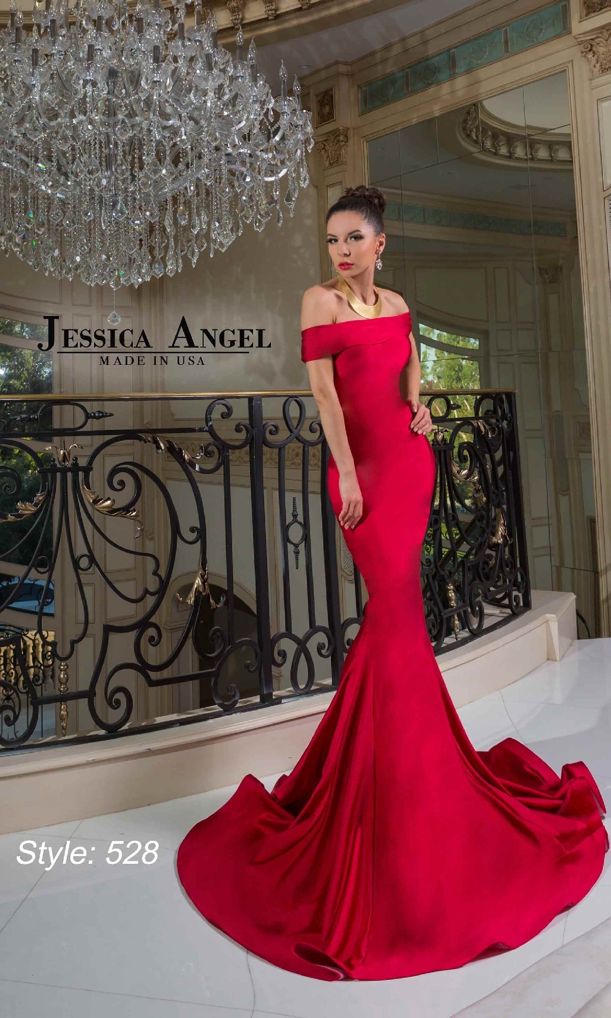 A woman poses by a black railing under a chandelier wearing the Off-Shoulder Long Prom Dress: Jessica Angel 528.